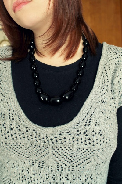 black necklace grey sweater closeup